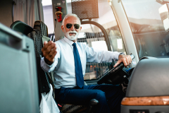 Mature beard bus driver sitting in bus.