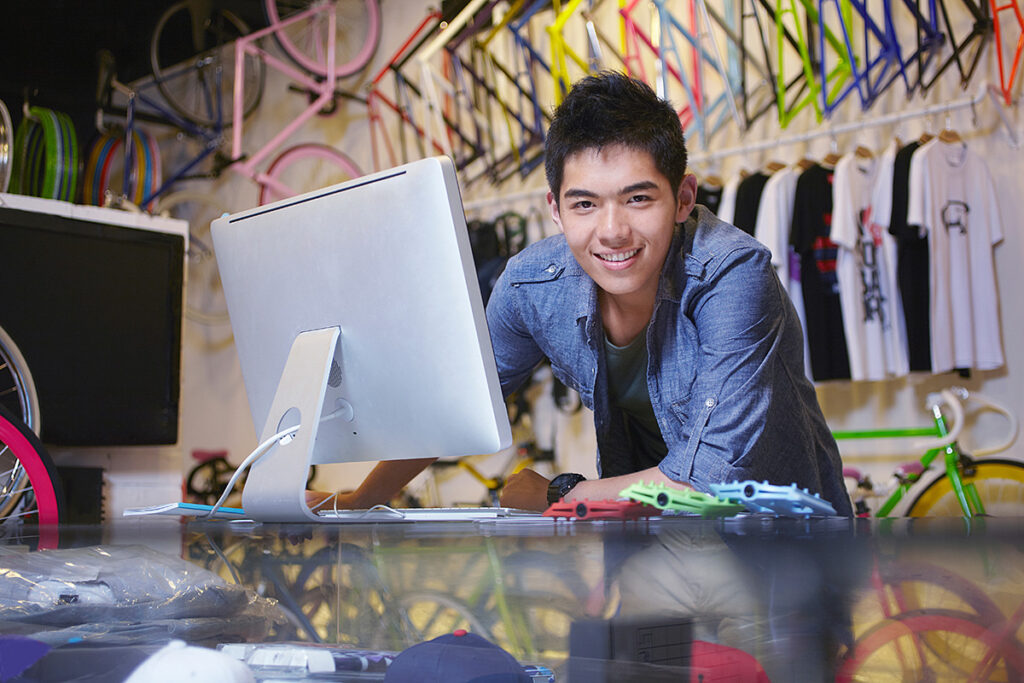 business owner working behind a computer at a bike retail store