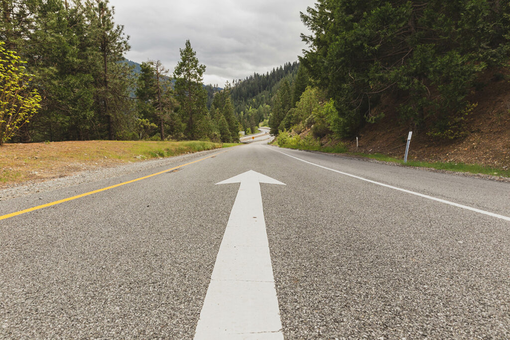 road painted with white arrow pointing onwards