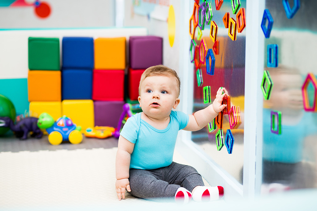 Toddler playing with magentic shapes at childcare centre