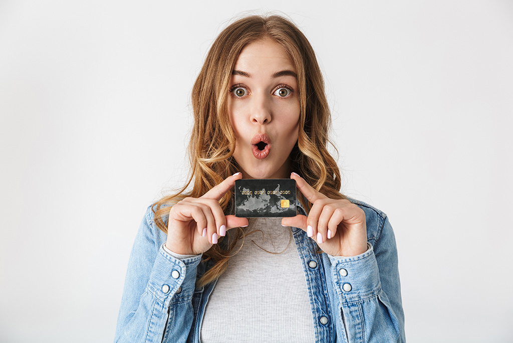 excited woman holding black gift card