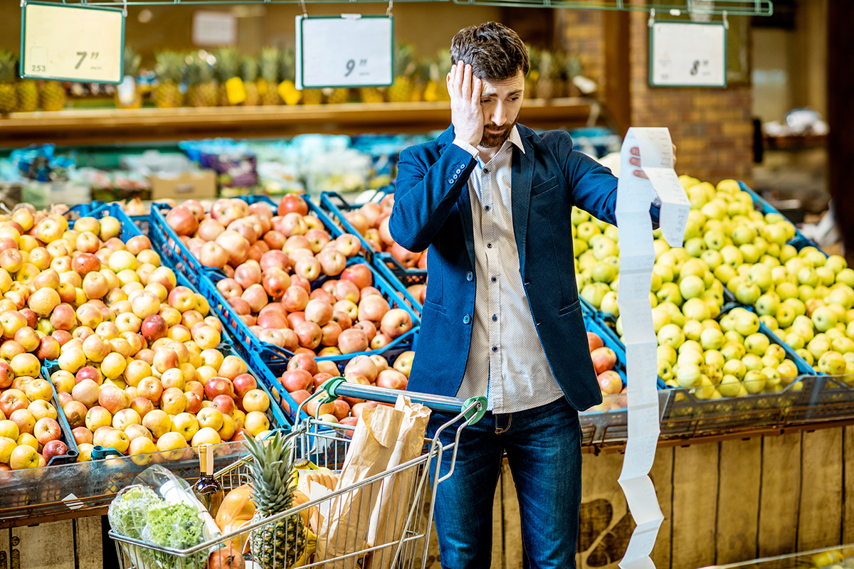 concerned man looking at supermarket shopping receipt