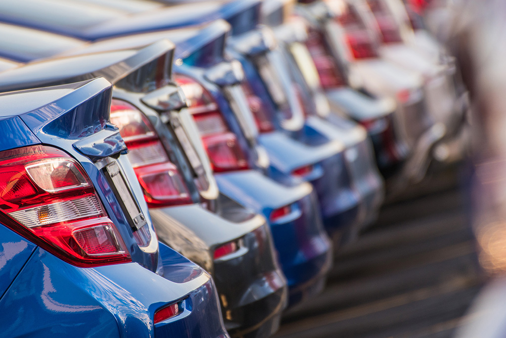 line of parked cars at car dealership