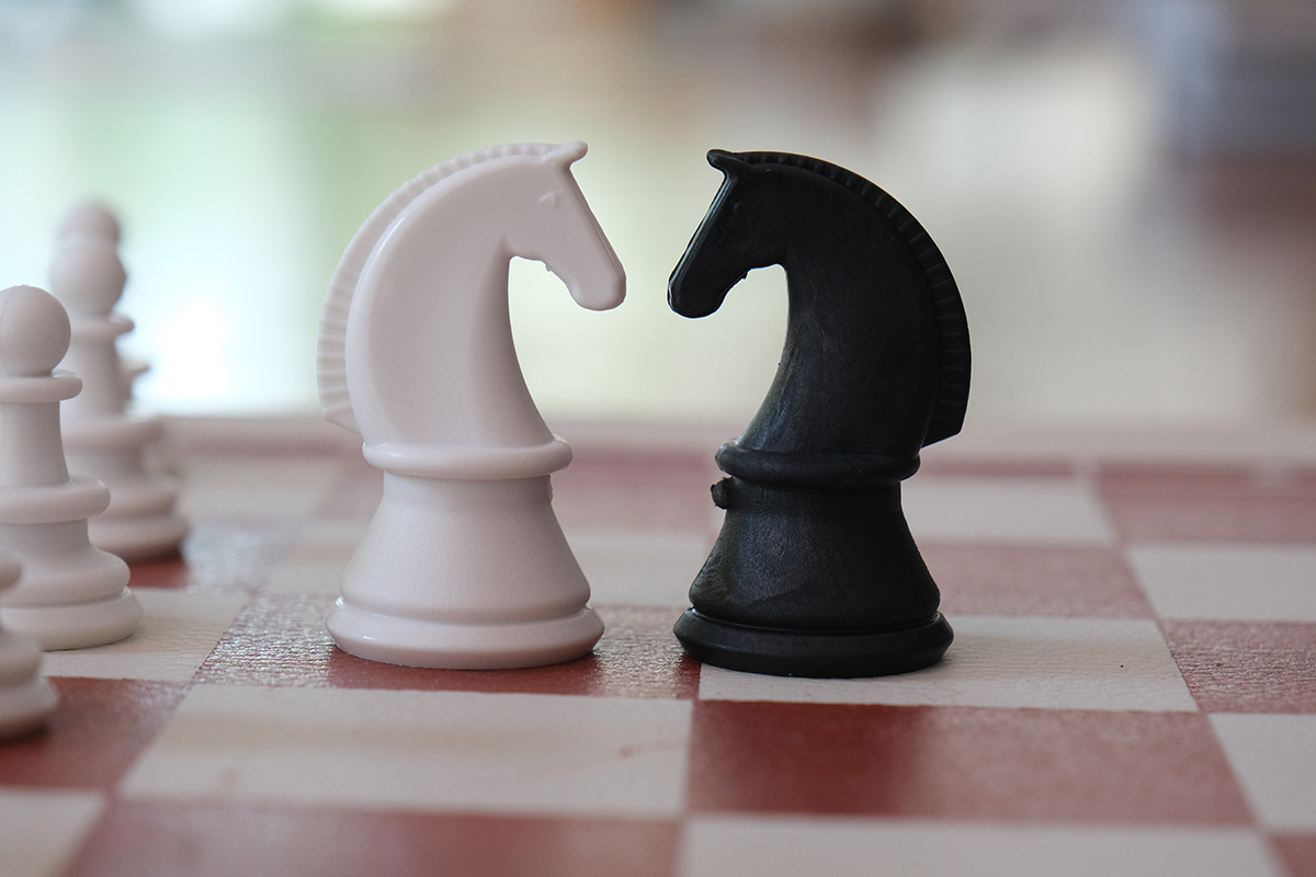 Opposing knight chess pieces facing each other