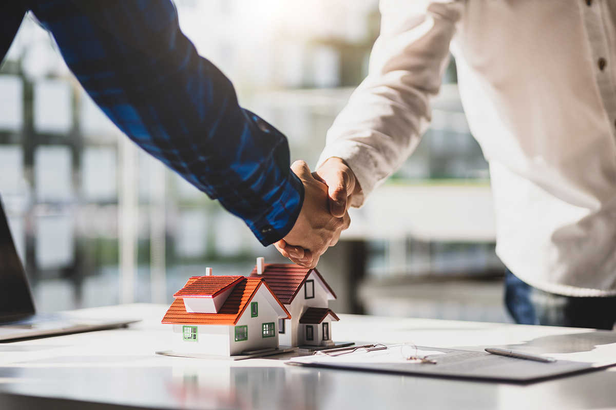 two men shaking hands about financial agreement on property