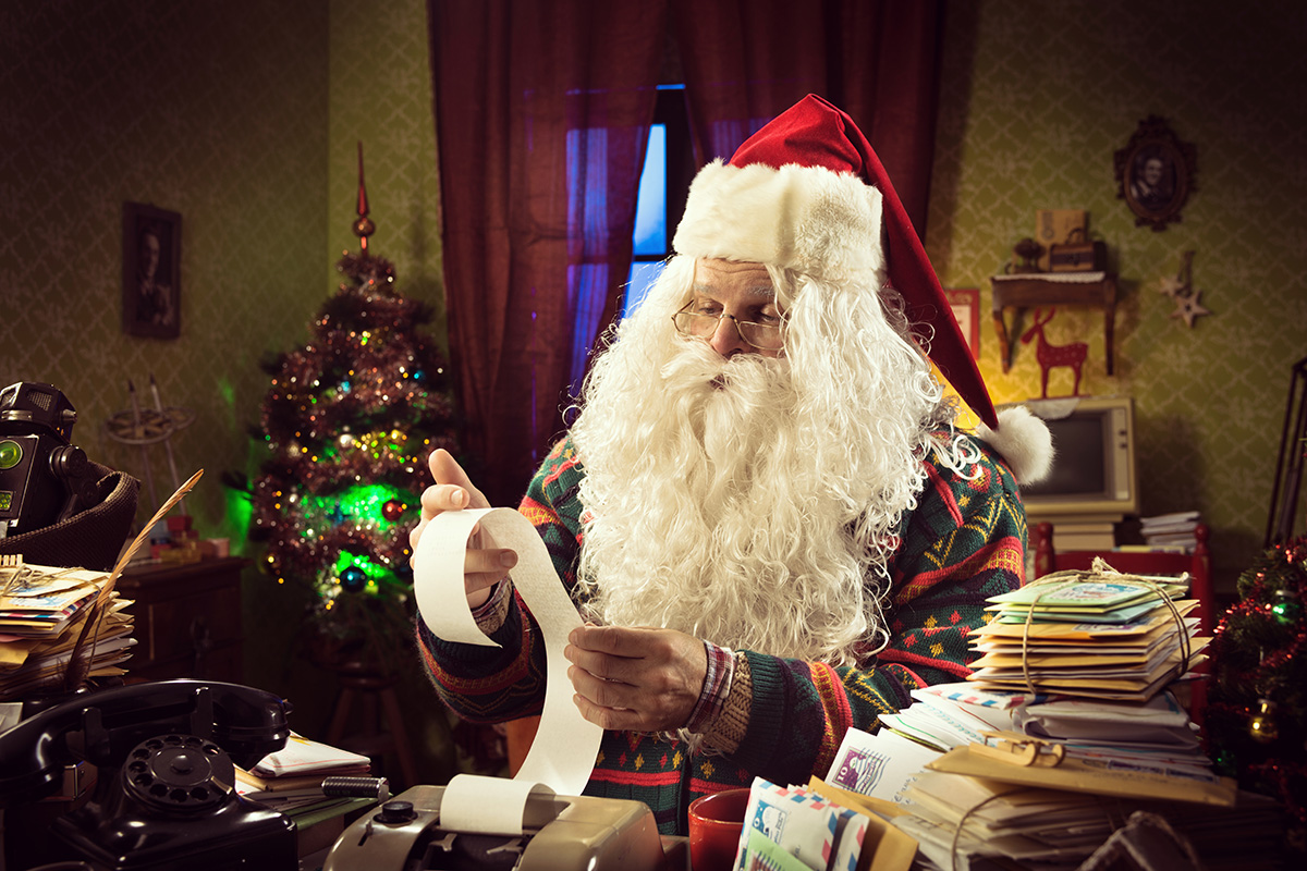 Santa Claus reading over a paper receipt