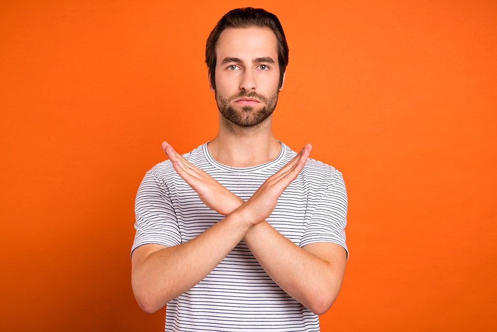 man forming an x with arms