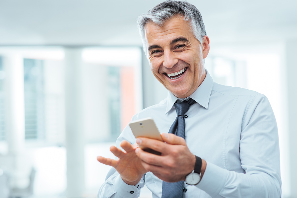 happy businessman scrolling on phone