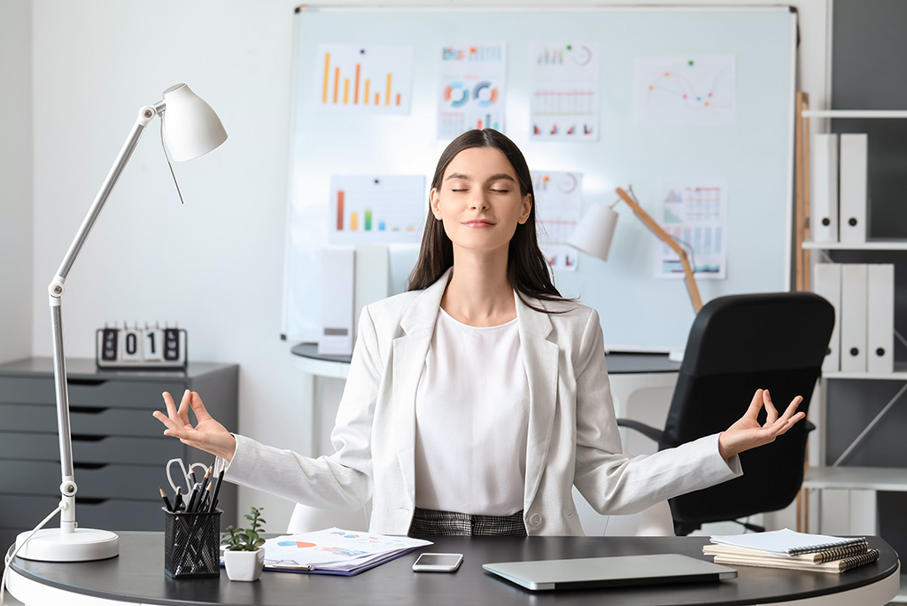 business woman meditating in her office